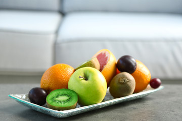 Fresh fruits on table in living room, close up