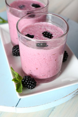 Fototapeta na wymiar Delicious berry smoothie with blackberries on wooden table close up