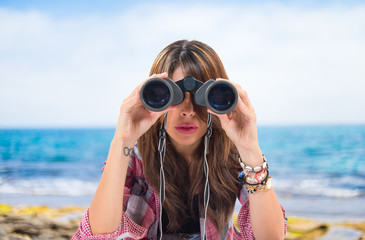 Girl with binoculats over isolated white background