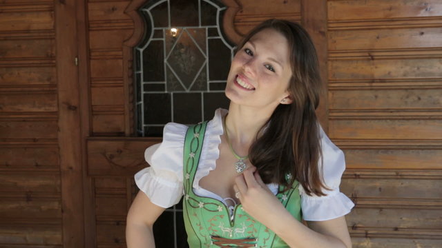 woman in dirndl standing in a doorway and smiles at camera