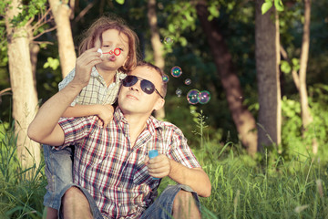 Father and son playing at the park at the day time.