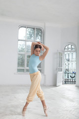 Fototapeta premium young modern ballet dancer posing on white background