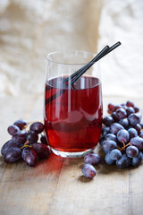 Glas mit rotem Traubensaft und Früchten