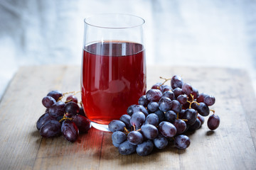 Glas mit rotem Traubensaft und Früchten