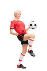 Young female soccer player juggling a ball