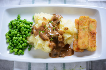 Kartoffelbrei mit Gemüsestäbchen und Erbsen