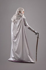 Fototapeta na wymiar Female Knight In Shining Armour with sword isolated on the gray background