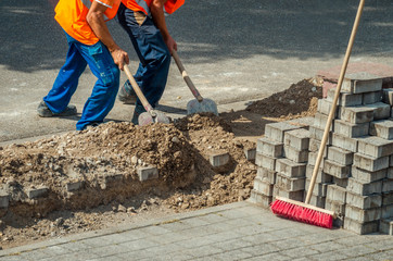 Bauarbeiter schaufeln Erde in Baugrube