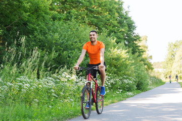 happy young man riding bicycle outdoors