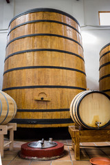 Big and small yellow barrels with iron rims and plastakovy bottles with drinks.