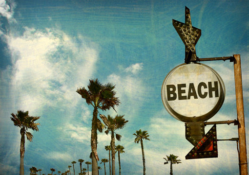 aged and worn vintage beach sign with palm trees