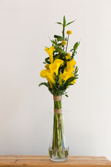 Bunch of yellow callas in the vase on white background