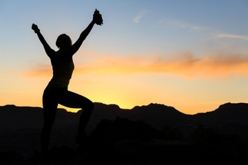 Fototapeta na wymiar Woman climbing success silhouette in mountains sunset