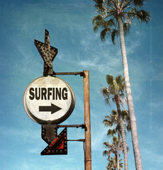 aged and worn vintage photo of surfing sign with arrow