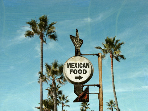 aged and worn vintage photo of mexican food sign with palm trees