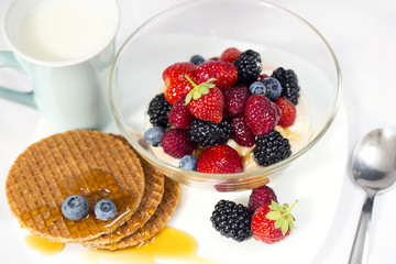 Tasty breakfast with yogurt, waffles, berries and milk