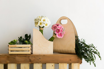The composition and bouquets of pink and white gerbera and eucalyptus in a wooden box