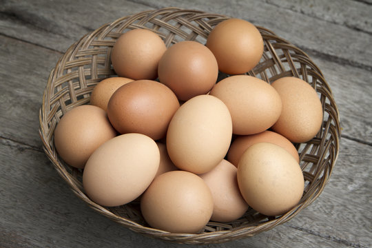 a lot of fresh eggs in basket on wooden.