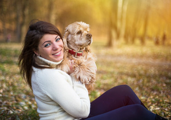 Pretty woman with beautiful cocker spaniel in autumn park