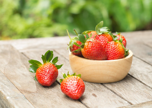 Red strawberry in a wooden bowl
