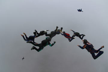 Skydive friends diving among the clouds