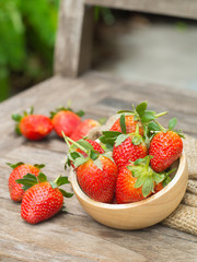 Fresh red strawberry in a wooden bowl