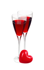 Two glass with red wine and red heart isolated on white