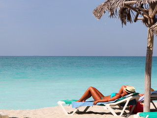 femme bronzant sous un palapa