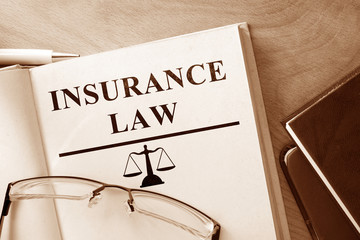 Book with words Insurance Law and glasses.