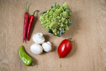 Champignon, hot peppers, yellow pepper, red tomato, savoy on wood background