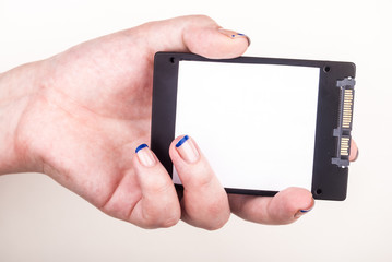 Female hand with SSD drive on white