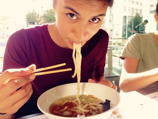 teenage girl eating asian noodle soup