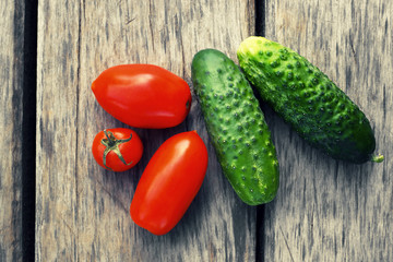 	

 Cucumbers and tomatoes.The background of the tree structure.Vegetable growing.