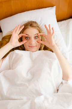 Funny female trying to wakeup opening her eyes with fingers