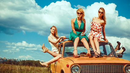 Five beautiful women on the old car.