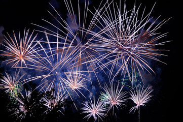 White blue and golden amazing fireworks on dark background