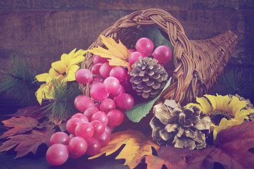 Thanksgiving cornucopia on wood background.