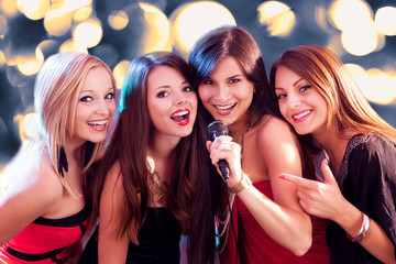 Four beautiful girls singing karaoke - obrazy, fototapety, plakaty