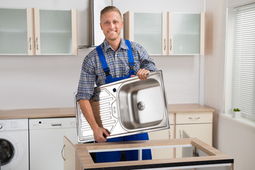 Male Plumber Carrying Sink