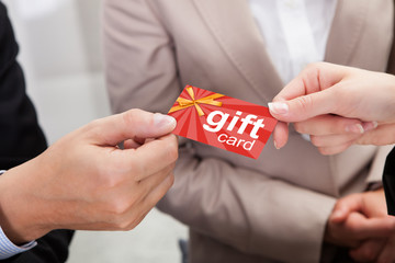 Businessperson Hands Giving Gift Card To Other Businessperson