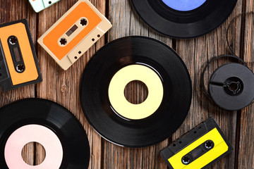 dischi in vinile, audiocassette e nastro super 8 sul tavolo di legno