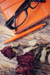 Dried red roses with book