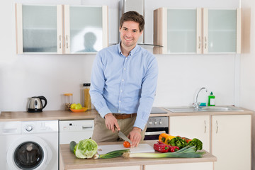 Man Chopping Vegetables In Kitchen