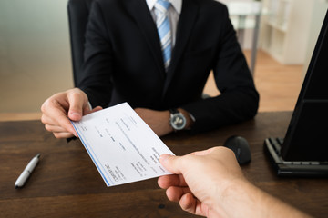 Businessman Giving Cheque To Other Person - obrazy, fototapety, plakaty