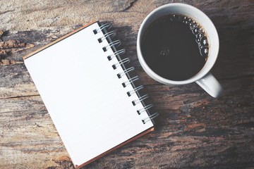 Blank notepad with hot coffee on office table