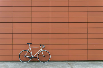 White fixie bike in orange wall - 90093277
