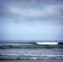 aged and worn vintage photo of ocean waves with surfers