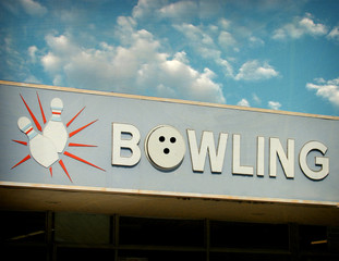 aged and worn vintage photo of bowling sign with pins and ball