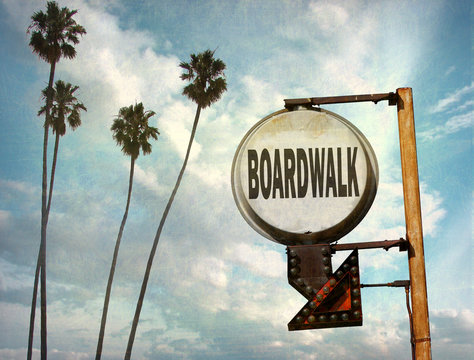aged and worn vintage photo of boardwalk sign on beach