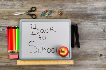 Back to school on white board with school supplies